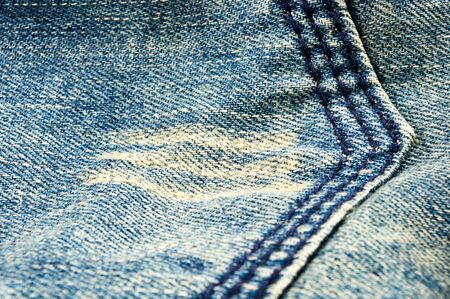 clothing items blue washed faded jeans cotton fabric texture with seams, clasps, buttons and rivets,...