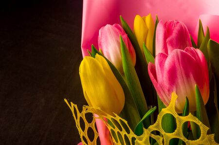 Background for a greeting card - a bouquet of fresh spring pink and yellow tulipsの写真素材