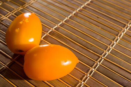 Still life - yellow and chocolate tomatoes on bamboo Matの写真素材