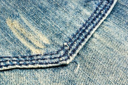 clothing items blue washed faded jeans cotton fabric texture with seams, clasps, buttons and rivets, macroの写真素材
