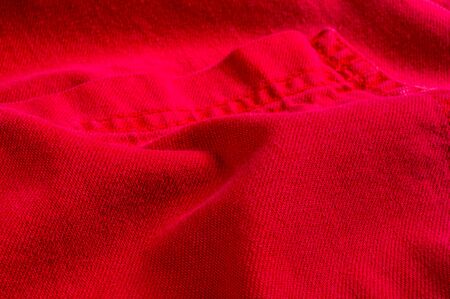 clothing items washed red cotton fabric texture with seams, clasps, buttons and rivets, macro, close-upの写真素材