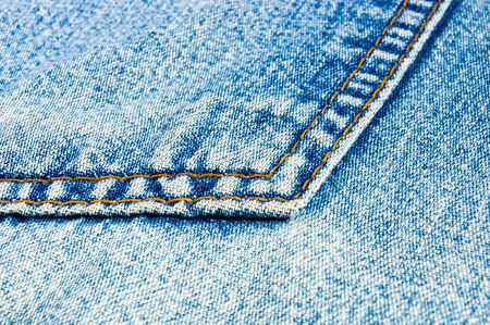 clothing items blue washed faded jeans cotton fabric texture with seams, clasps, buttons and rivets, macroの写真素材