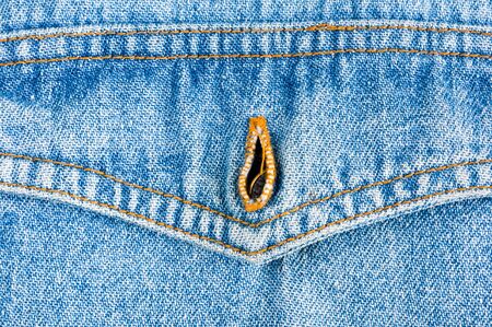 clothing items blue washed faded jeans cotton fabric texture with seams, clasps, buttons and rivets, macroの写真素材