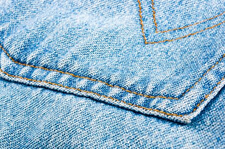 clothing items blue washed faded jeans cotton fabric texture with seams, clasps, buttons and rivets, macroの写真素材