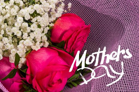 Holiday card - a bouquet of bright fresh red roses in a festive package, holiday greetings, handwritten inscription with a brush Mothers Day, greeting lettering.の写真素材