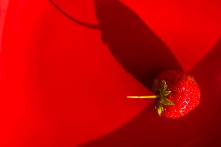 fresh ripe berries strawberries on red ceramic plate, macroの写真素材