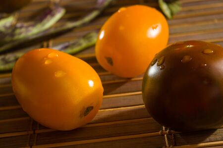 Still life - asparagus beans, purple Basil, yellow and chocolate tomatoes on bamboo Matの写真素材