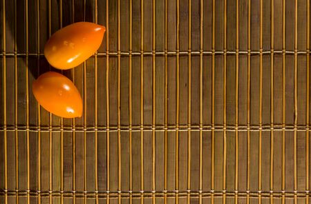 Still life - yellow and chocolate tomatoes on bamboo Matの写真素材