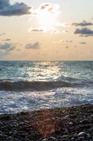 sea landscape is a pebbly beach with waves in white foam, a beautiful sky with clouds, a warm summer dayの写真素材