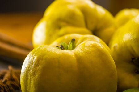 still life - large yellow quince fruits on a ceramic plate, with anise, cinnamon, and walnutsの写真素材