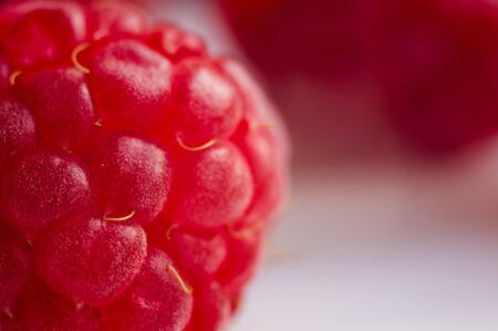 big fresh juicy raspberries on a white saucer close up, macro photo, selected focusの写真素材