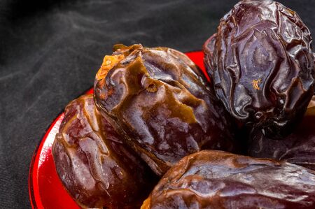 Big luxury dried date fruit in bowls on the dark surface, kurma ramadan kareem concept.の写真素材