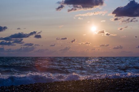 Summer sea sunset, the sun, waves and clouds, beautiful dramatic lightingの写真素材