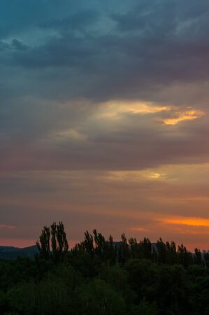 Landscape with dramatic light - beautiful golden sunset with saturated sky and clouds, peaceful nature serene background.の写真素材