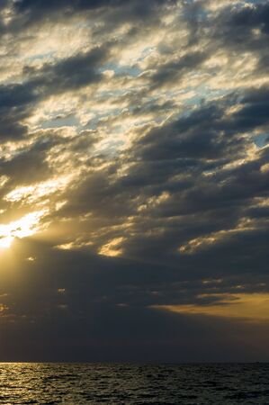 Summer sea sunset, the sun, waves and clouds, beautiful dramatic lightingの写真素材