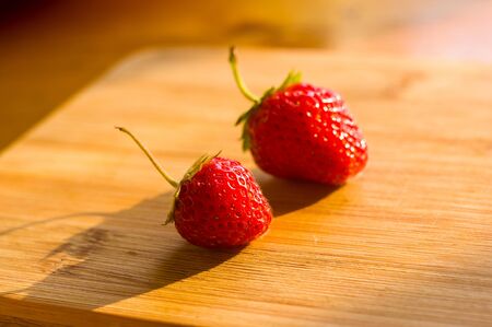 fresh ripe berries strawberries on bamboo board, macroの写真素材