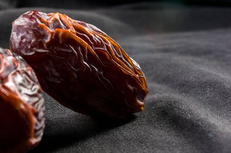 Big luxury dried date fruit on the dark surface, kurma ramadan kareem concept.