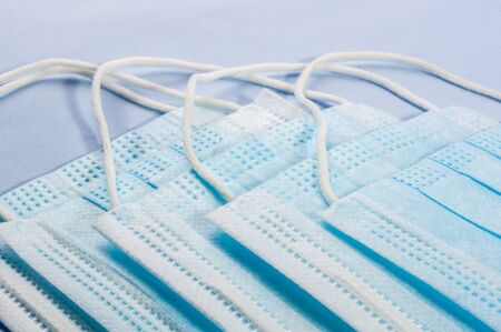 Background concept for news about the novel coronavirus COVID-19 pandemic, antiviral medical mask for protection against coronavirus. Surgical protective mask. Medical respiratory bandage face and thermometer, lettering on copy space.の写真素材