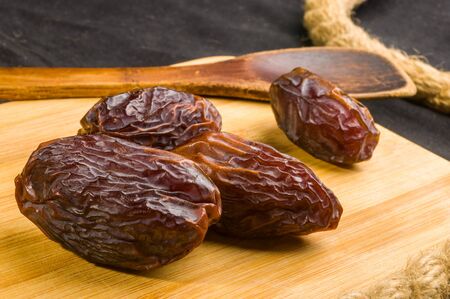 Big luxury dried date fruit on the wooden board, kurma ramadan kareem concept.の写真素材