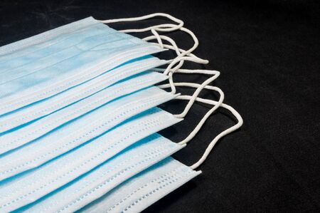 Background concept for news about the novel coronavirus COVID-19 pandemic, antiviral medical mask for protection against coronavirus. Surgical protective mask. Medical respiratory bandage face and thermometer, lettering on copy space.の写真素材