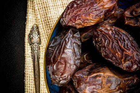 Big luxury dried date fruit in bowls on a linen napkin, kurma ramadan kareem concept.の写真素材