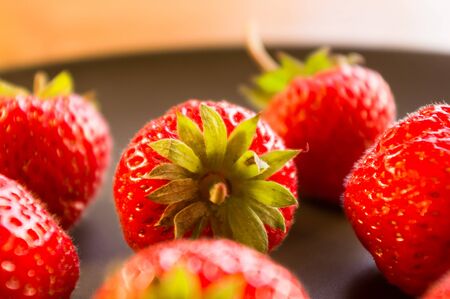 fresh ripe berries strawberries on black ceramic plateの写真素材