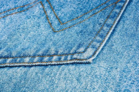 clothing items blue washed faded jeans cotton fabric texture with seams, clasps, buttons and rivets, macroの写真素材