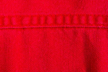 clothing items washed red cotton fabric texture with seams, clasps, buttons and rivets, macro, close-upの写真素材