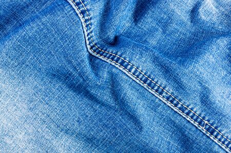 clothing items blue washed faded jeans cotton fabric texture with seams, clasps, buttons and rivets, macroの写真素材