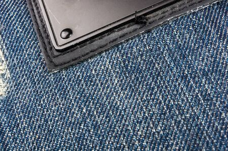 clothing items blue washed faded jeans cotton fabric texture with seams, clasps, buttons and rivets,...