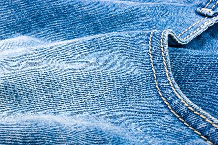 clothing items blue washed faded jeans cotton fabric texture with seams, clasps, buttons and rivets, macroの写真素材