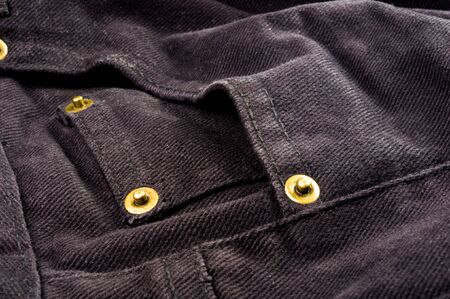 clothing items washed cotton fabric texture with seams, clasps, buttons and rivets, macro, close-up