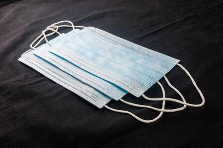 Background concept for news about the novel coronavirus COVID-19 pandemic, antiviral medical mask for protection against coronavirus. Surgical protective mask. Medical respiratory bandage face and thermometerの写真素材