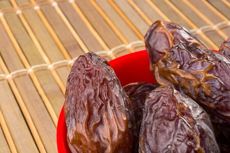 Big luxury dried date fruit in bowls on the bamboo mat, kurma ramadan kareem concept.の写真素材
