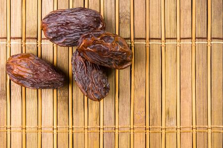 Big luxury dried date fruit on the bamboo mat, kurma ramadan kareem concept.の写真素材