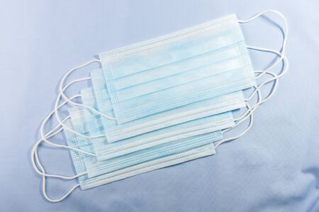 Background concept for news about the novel coronavirus COVID-19 pandemic, antiviral medical mask for protection against coronavirus. Surgical protective mask. Medical respiratory bandage face and thermometer, lettering on copy space.の写真素材