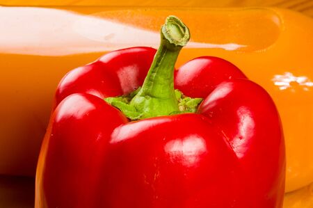 fresh red paprika, bell pepper and a bottle of pumpkin juice, close up