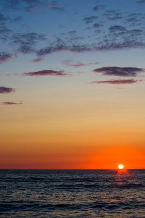 Summer sea sunset, the sun, waves and clouds, beautiful dramatic lightingの写真素材