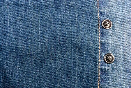 clothing items blue washed faded jeans cotton fabric texture with seams, clasps, buttons and rivets, macroの写真素材
