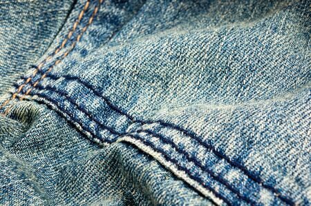 clothing items blue washed faded jeans cotton fabric texture with seams, clasps, buttons and rivets, macroの写真素材