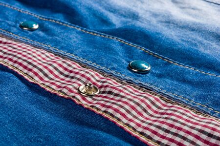 clothing items blue washed faded jeans cotton fabric texture with seams, clasps, buttons and rivets, macroの写真素材