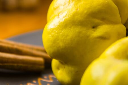 still life - large yellow quince fruits on a ceramic plate, with anise, cinnamon, and walnutsの写真素材