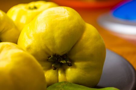 still life - large yellow quince fruits on a ceramic plate, with anise, cinnamon, and walnutsの写真素材