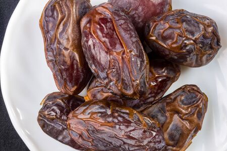Big luxury dried date fruit in bowls on the dark surface, kurma ramadan kareem concept.の写真素材