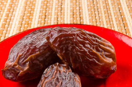 Big luxury dried date fruit in bowls on the bamboo mat, kurma ramadan kareem concept.の写真素材