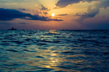 Summer sea sunset, the sun, waves and clouds, beautiful dramatic lightingの写真素材