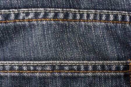 clothing items blue washed faded jeans cotton fabric texture with seams, clasps, buttons and rivets, macroの写真素材