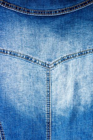 clothing items blue washed faded jeans cotton fabric texture with seams, clasps, buttons and rivets, macroの写真素材