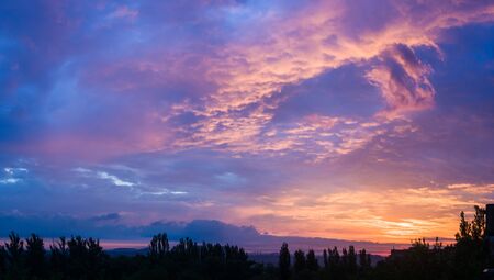Landscape with dramatic light - beautiful golden sunset with saturated sky and clouds, peaceful nature serene background.の写真素材