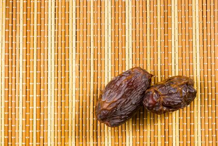 Big luxury dried date fruit on the bamboo mat, kurma ramadan kareem concept.の写真素材